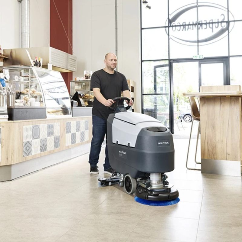 Nilfisk SC401 Mid Sized Walk Behind Scrubber Dryer Man In Cafe