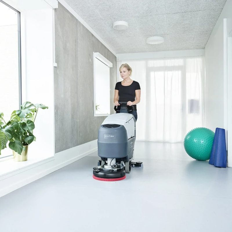Nilfisk SC401 Mid Sized Walk Behind Scrubber Dryer Woman In Fitness Studio
