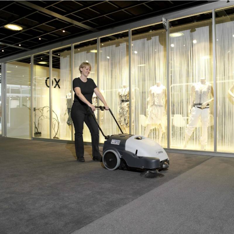 Nilfisk SW750 Mid Sized Walk Behind Sweeper Used By Woman